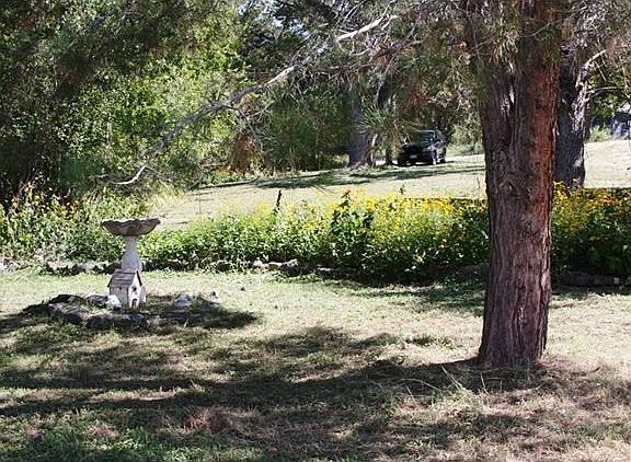 Front yard with garden and bird bath.