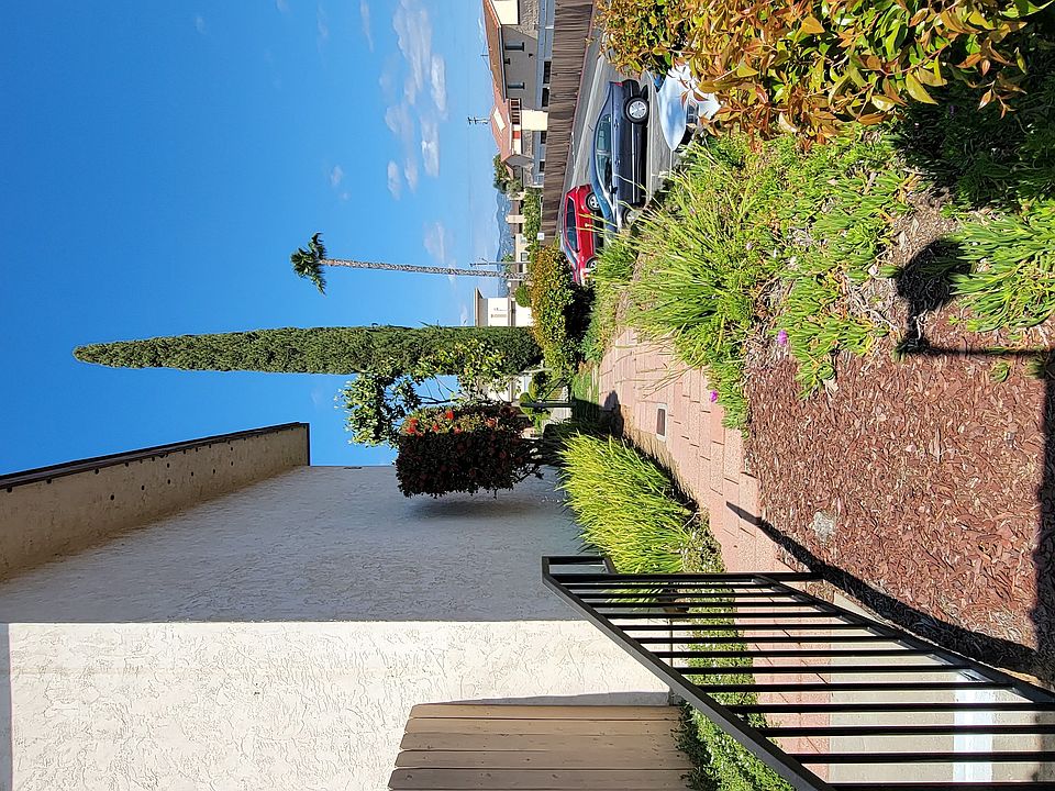 Paver walkway and gardens around apartment building at Plaza Verde Apartments in Escondido, California.