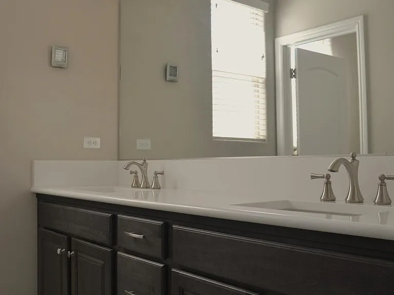 Bathroom 3 located in the west wing of the house has double sink, quartz countertops, and separate bath area.