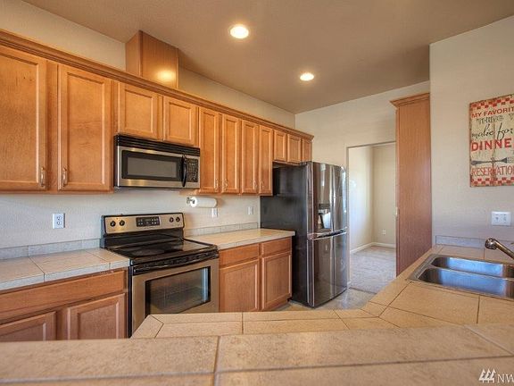 Open kitchen with tile countertops and tons of cabinet space. 