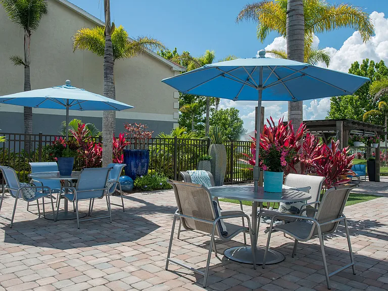 Our expansive sundeck features plenty of tables with umbrellas for residents to relax and dine poolside.