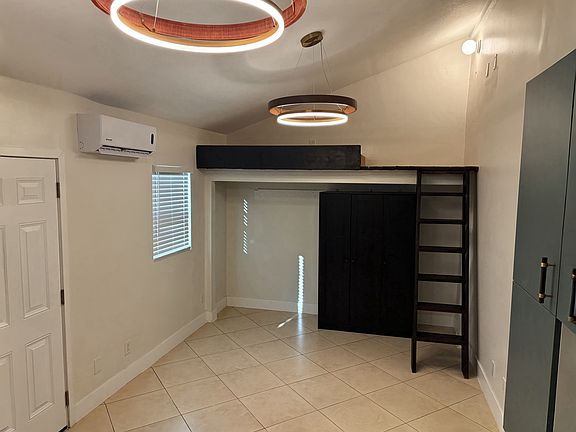 Main Living Area _ Bright 250 sq ft layout with a lofted sleeping nook above the closet.