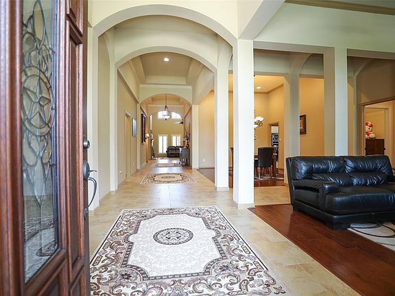 Triple Arched Entry Hall is Extra Wide with Soaring Ceilings*Neutral Palate on Tile floors*Natural Hardwoods are in both Formals.