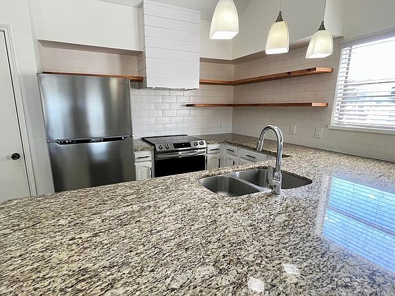 Kitchen / newly remodeled; features stainless steel appliances (fridge, stove, dishwasher, hood went).
