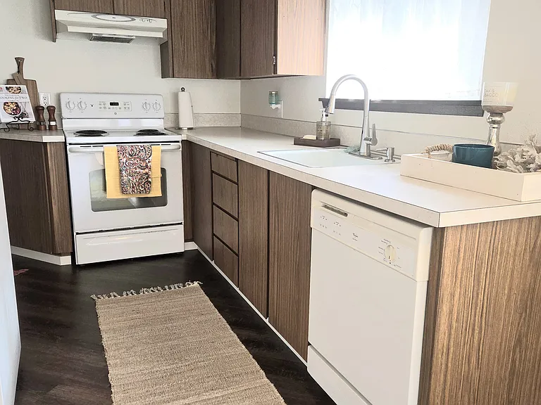 View of spacious galley kitchen, from the dining/front room. (rugs and staging items not included).