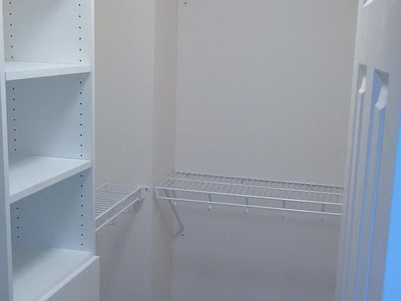 walk-in closet with drawers and shelving.