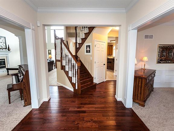 Entry foyer with newer hardwood flooring & T staircase. Formal living and dining rooms have wainscoting and crown molding.