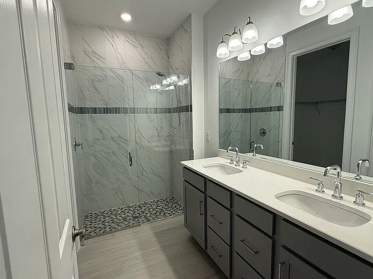 The Master Bath boasts high end flooring, and a walk-in shower with custom tile and seamless glass doors.