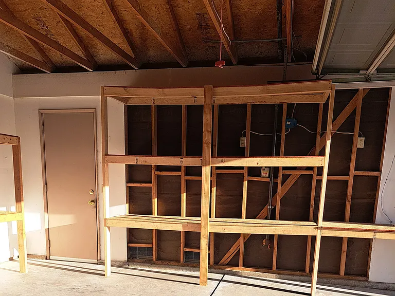 Right side of garage, more storage shelves. Door leads to side yard.