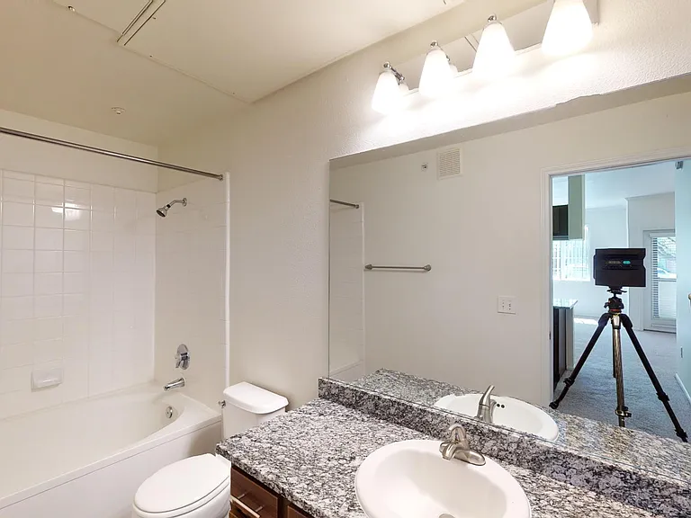 Apartment bathroom with large soaking tub and wood-style flooring.