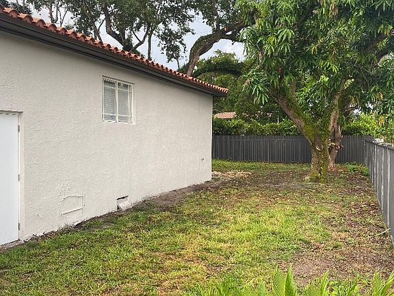 Side of home with Mango tree