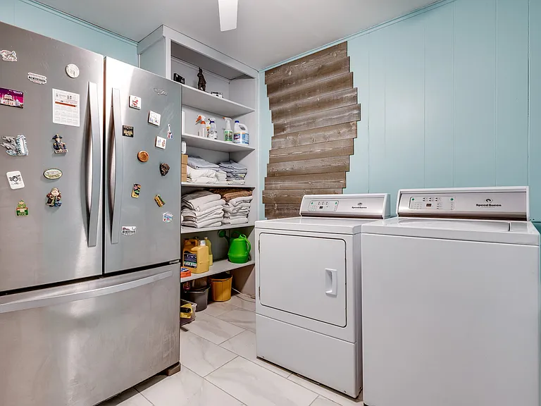 Large stainless steel refrigerator and full size washer and dryer.