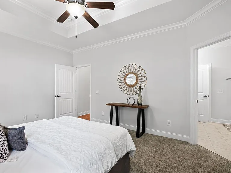 Master bedroom looking toward hallway door to the left and bathroom to the right.