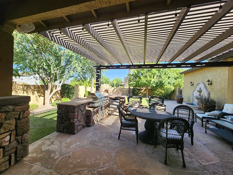 Outdoor dining with grill and refrigerator. String lights add. to ambience.