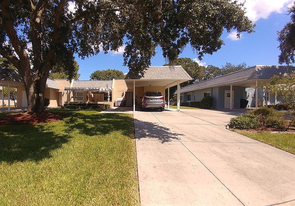 Long driveway. With covered parking and Add'l parking. Pergola shaded front porch with table, chairs & umbrella.
