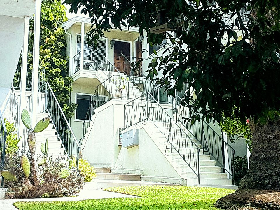 Charming cottage-like apartment in small 6-unit building. Front lawn with grass and palm trees.