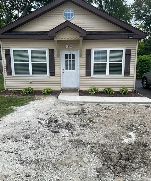 New sidewalk and new driveway with landscaping in progress.