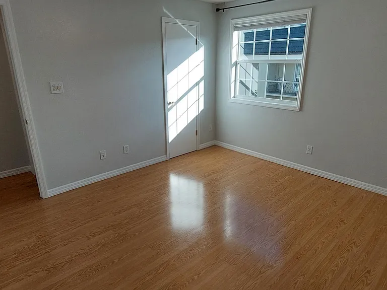 Secondary bedroom. 6' walk in closet next to window. Window looks out onto courtyard.