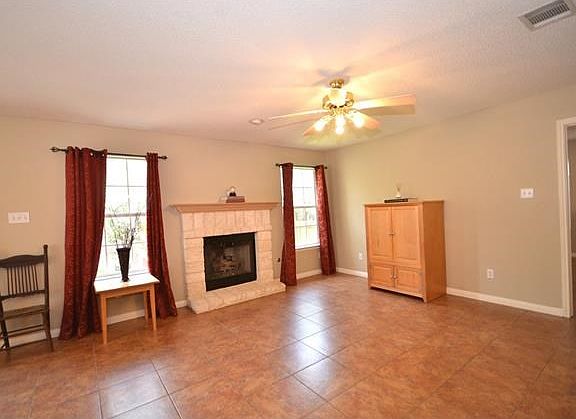 The spacious family room features a stone fireplace with gas logs.