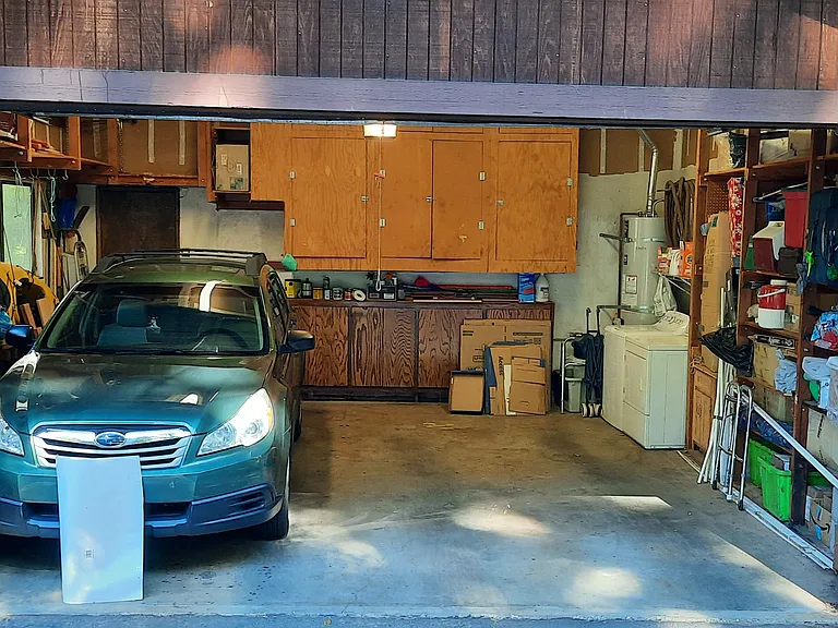 Two car garage with storage and washer and dryer. Garage can't fit a very large car, but there's driveway and street parking for large vehicles.