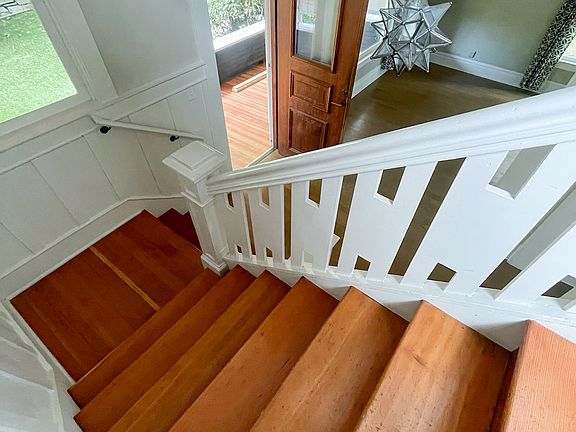 Stairs to the upper level featuring original woodwork