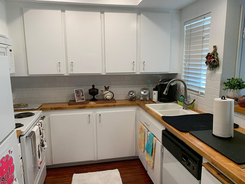 Adorable country kitchen with butcher block countertops and subway backslash