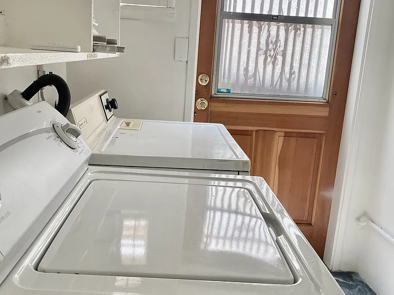 Laundry area with washer, dryer, and back door leading to the deck.