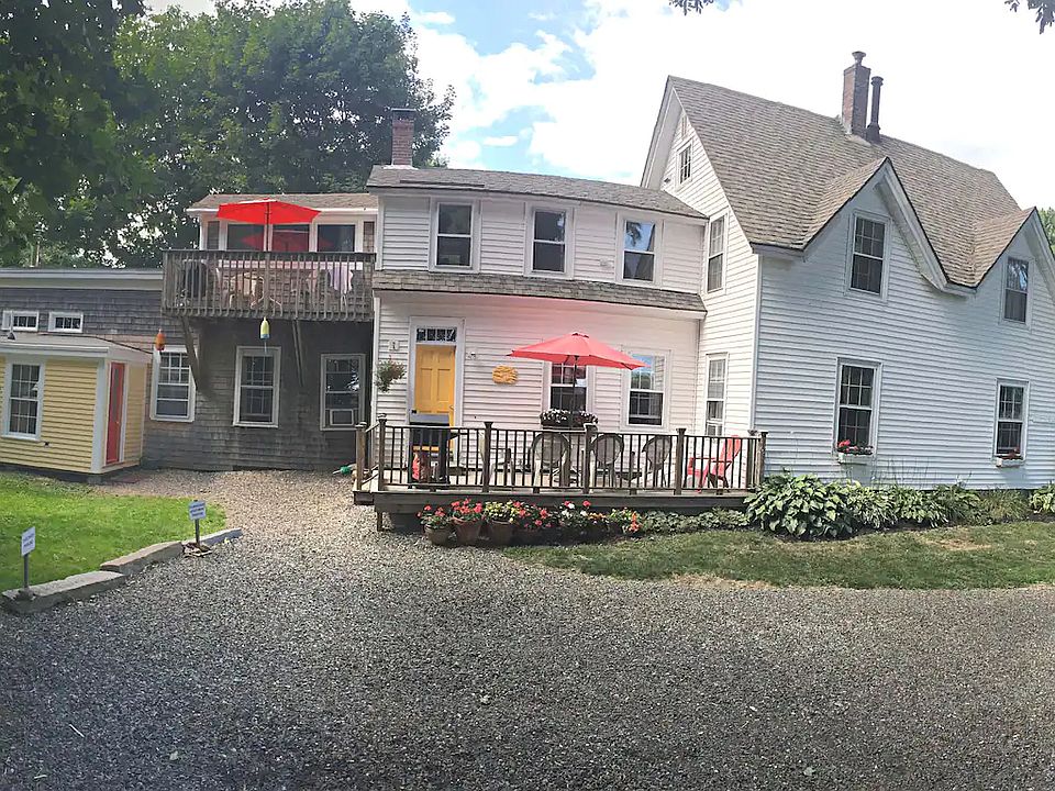 General view of the front of the house from the driveway. The Upstairs Apartment balcony deck is to the left. The owners apartment is to the far left, with the red door.