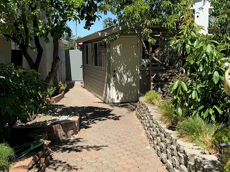 Private locked gate and entry path to cottage from the front