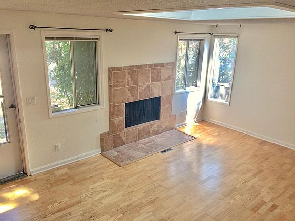 Living room with woodburning fireplace and lots of light.