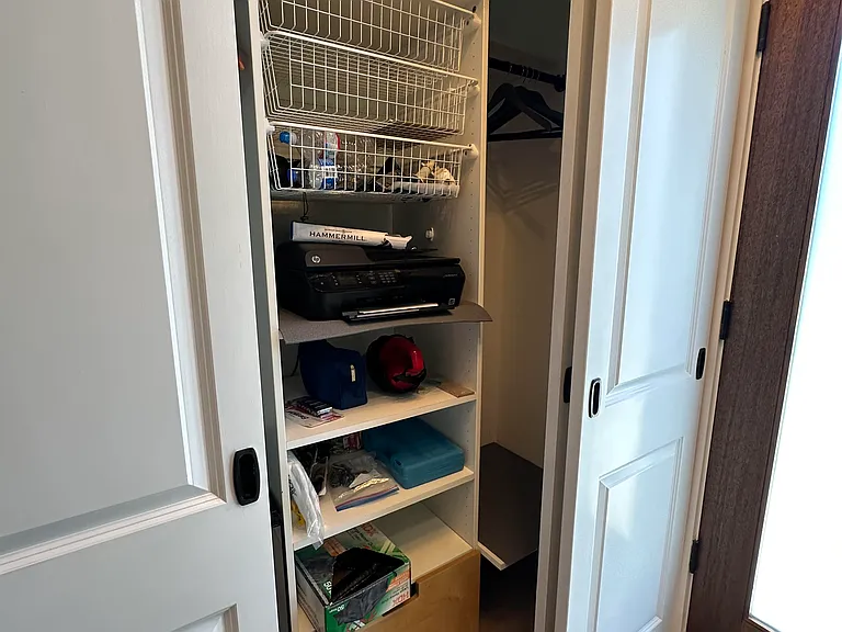 Storage/coat closet behind white barn-style doors to the left of front door