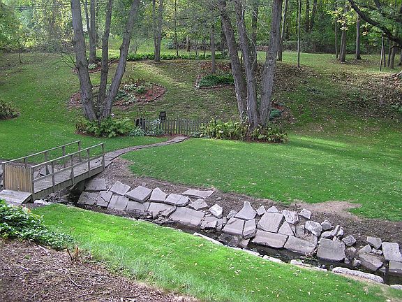 Beautiful Park-like backyard with babbling brook and wooden bridge