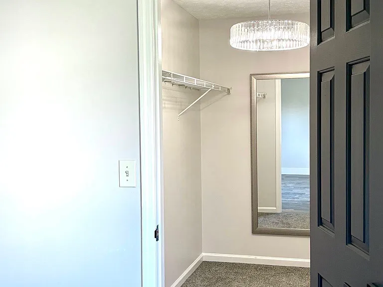 Large walk-in primary closet / dressing area, with full length mirror and glamorous lighting!