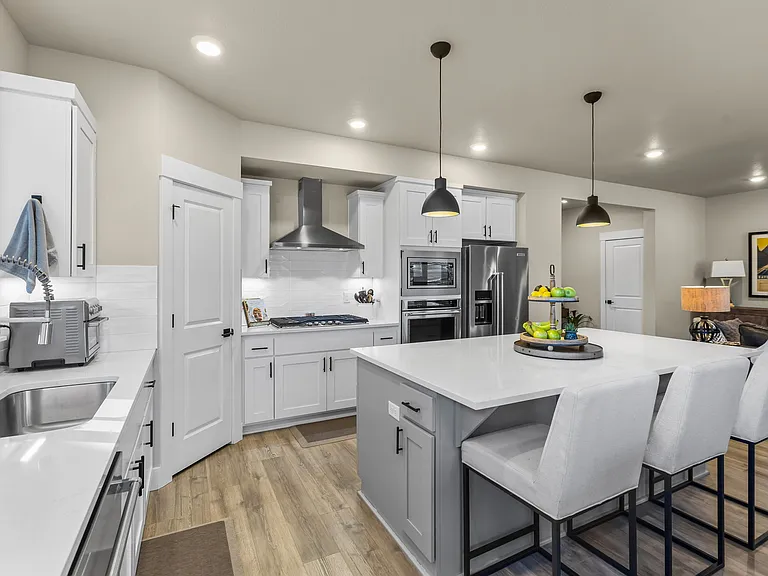 Large kitchen w/quartz countertops, island, walk-in pantry, stainless Kitchen Aid Appliances including gas cooktop, convection oven, microwave, dishwasher and refrigerator.