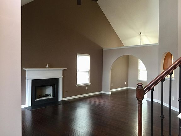 Large living room with beautiful high ceilings, fireplace, and lots of sunlight