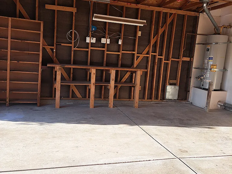 Left side of garage, work bench, extra shelves for storage.