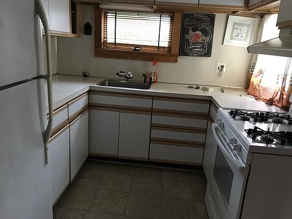 kitchen with ample cabinets, gas stove and refrigerator