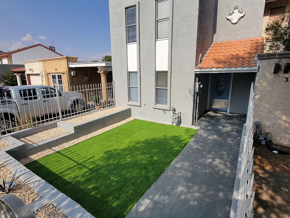 Front of townhome with artificial grass and rock scape.