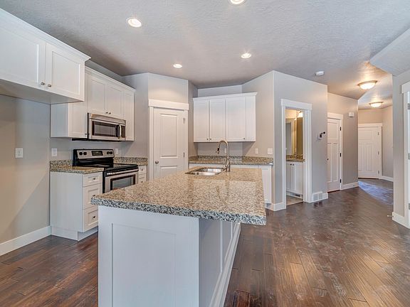 Kitchen with granite countertops and beautiful real wood floors. New stainless steel fence door Fridge included (not pictured here)