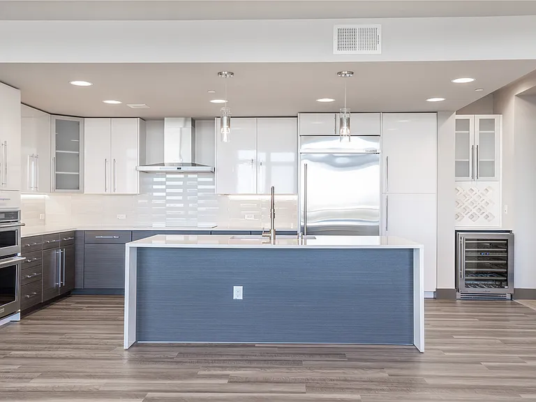 Quartz countertops, designer cabinets, stainless steel appliances and wine refrigerator in brand-new kitchen