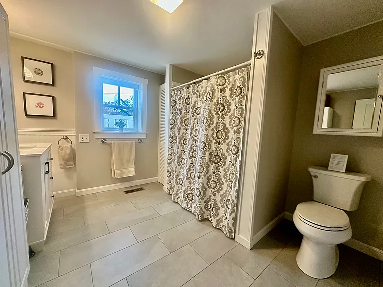 Renovated bathroom with walk-in shower and built in seat with removable shower head