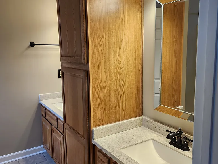 Master bathroom contains two separate vanities/mirrors and lots of storage underneath vanities and console in the middle of vanities.