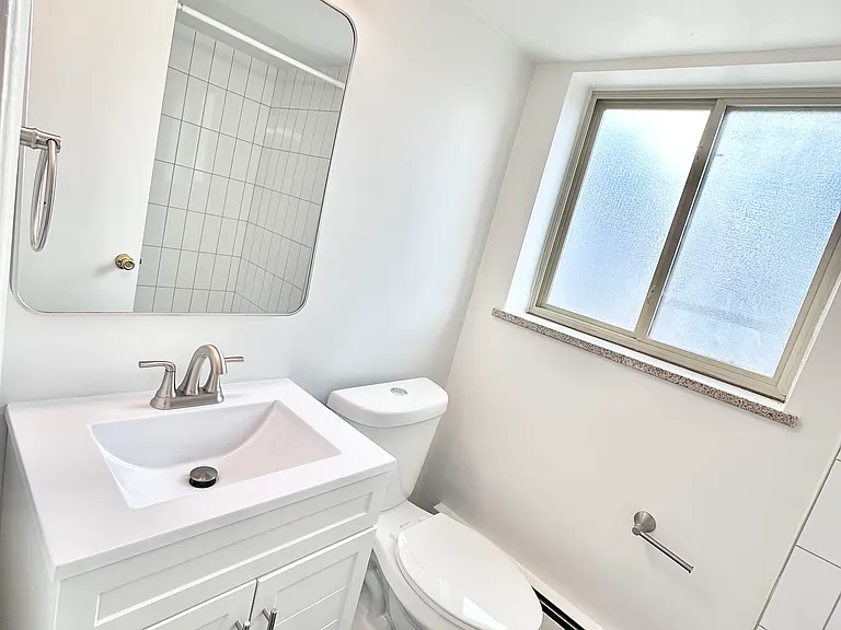 Bright, modern bathroom with hexagonal tile floor, sleek vanity, and large window for natural light. Bright, modern bathroom with hexagonal tile floor, sleek vanity, and large window for natural light.