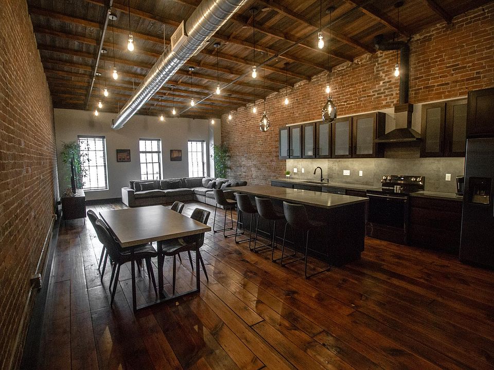 Open Design Concept - Professionally designed, living area, dining and kitchen, all with exposed brick. Beautiful custom cabinets, concrete counter tops and black stainless steel appliances.