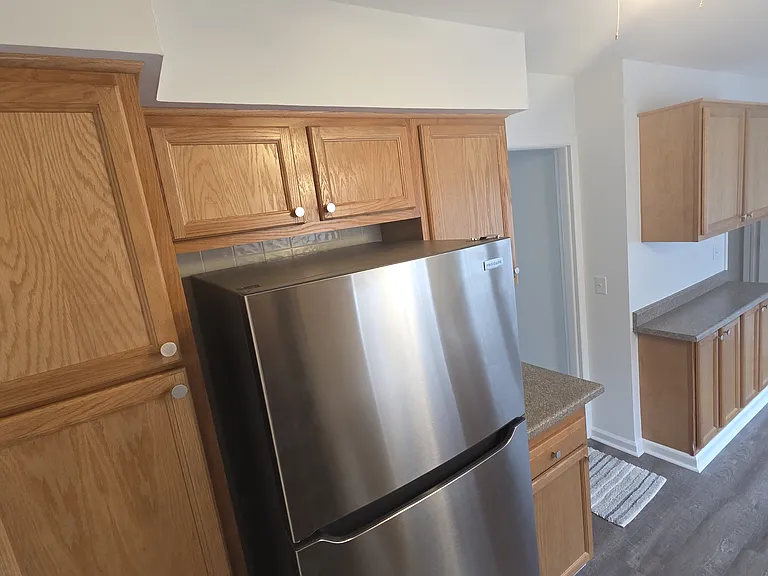 Bright renovated kitchen with new luxury vinyl plank flooring and generous cabinet storage.