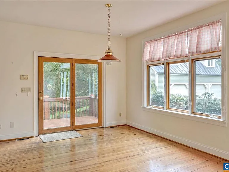 The kitchen nook is part of the open floor plan. This door steps out onto the entertainment deck. Front shrubbery provides privacy while sitting for dinner.