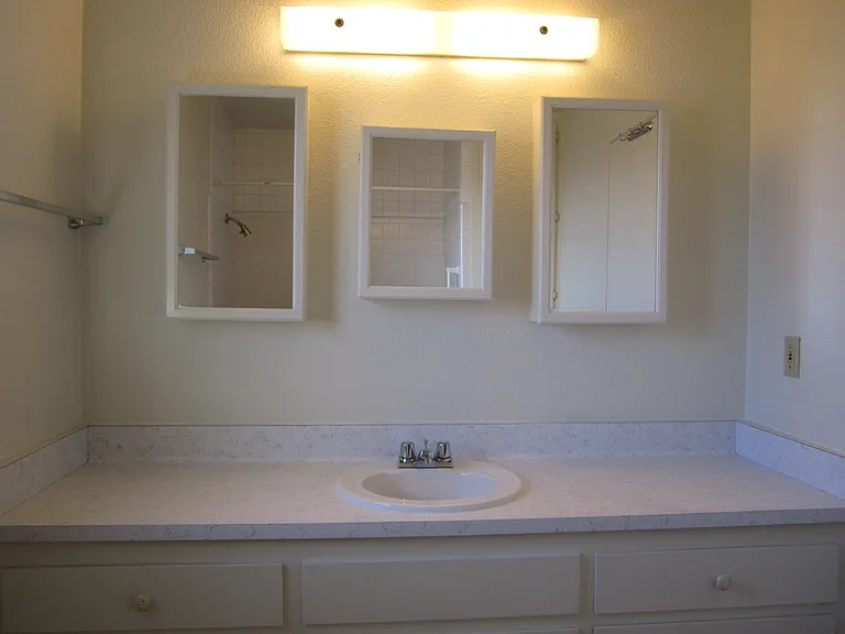 Upstairs bath with 3 medicine cabinets, sink, much cabinet area under sink and next to shower