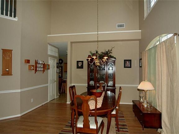 The dining room has a wall of windows, an elegant chandelier and decorative moldings.