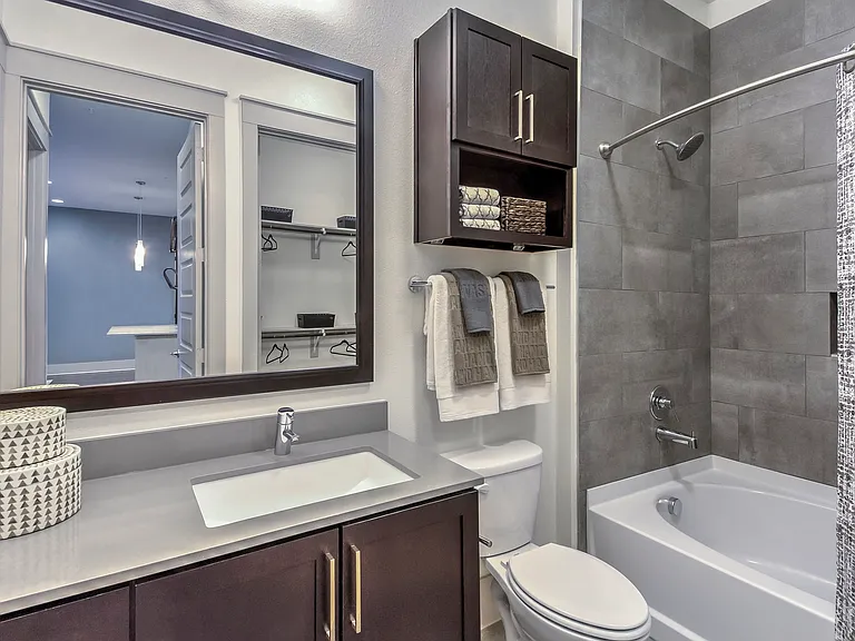 Bathrooms feature a frameless mirror and quartz countertops.