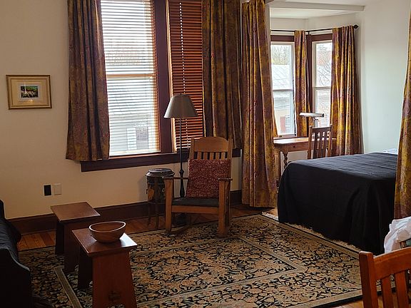 A view of the living room and adjoining sleeping and study nook. Curtains can be drawn to separate sleeping area from living room.